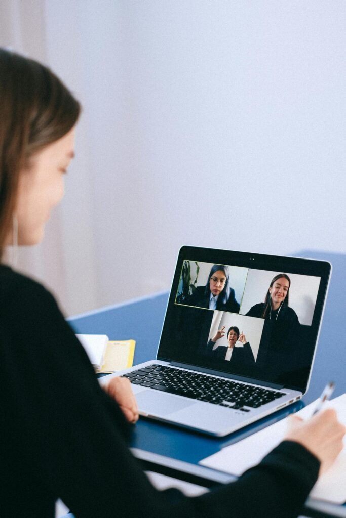 Remote Team Collaboration – Veritas Consulting Remote team video meeting featuring a professional woman engaging with colleagues on a laptop, highlighting Veritas Consulting's expertise in hybrid consulting, virtual HR solutions, and remote workforce engagement for MSMEs and growing businesses